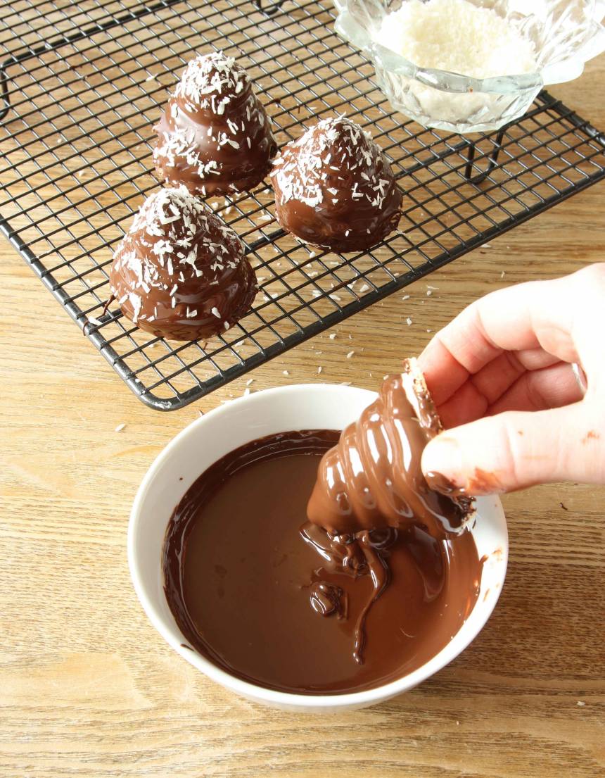 5. Smält chokladen över vattenbad och rör ner oljan till en slät smet. 7. Doppa mumsmumstopparna i chokladen och ställ den på ett galler. Strö över lite kokos. Låt chokladen stelna. Förvara dem i kylskåp. 