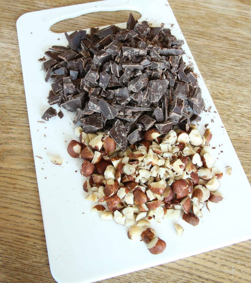 1. Sätt ugnen på 175 grader. Hacka chokladen och nötterna grovt (hälften av nötterna ska läggas i smeten och hälften ovanpå kakan).