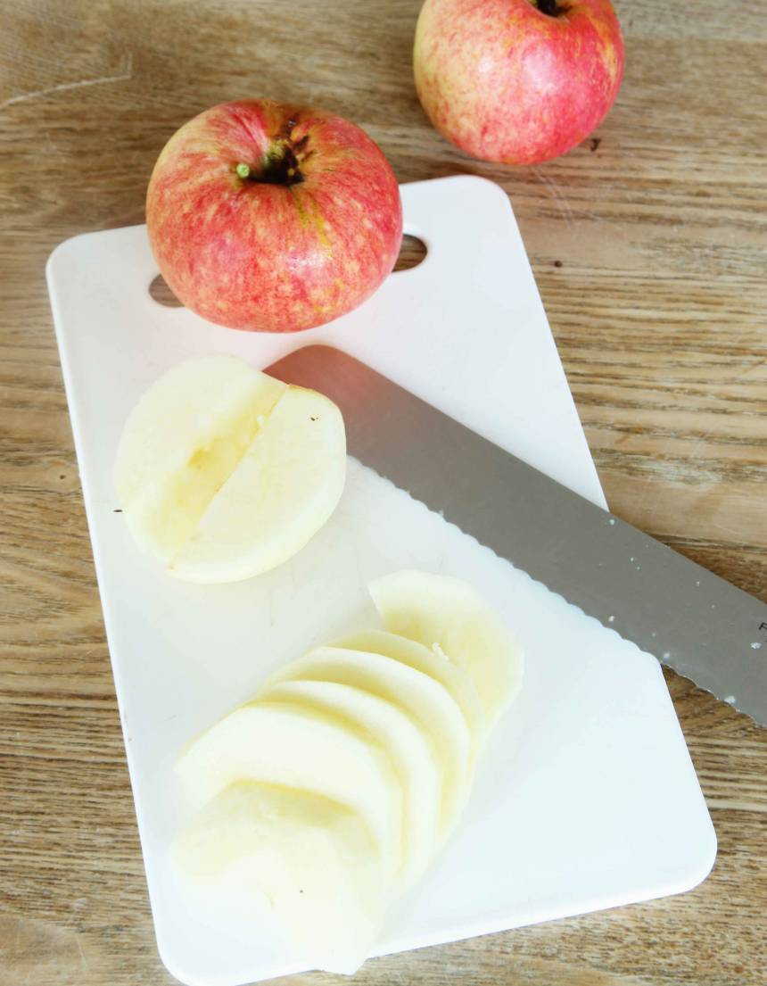 3. Skala äpplena, ta ur kärnhuset och dela dem på mitten. Skär äpplena i skivor, ca ½ cm tjocka.