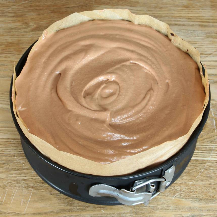 4. Chokladmousse: Koka upp grädden i en kastrull. Häll den över chokladen i en skål och rör om till en slät smet. 5. Koka upp socker och vatten. Stäng av plattan. Tillsätt äggulorna och vispa kraftigt med en elvisp till en krämig smet. 6. Vispa grädden lätt och blanda den försiktigt med äggsmeten och chokladsmeten. Bred ut moussen över bottnen. Ställ kakan i frysen i 3–4 tim. Ta fram kakan, strö över hyvlad choklad och servera den rumstempererad. Förvara kakan i kylen.
