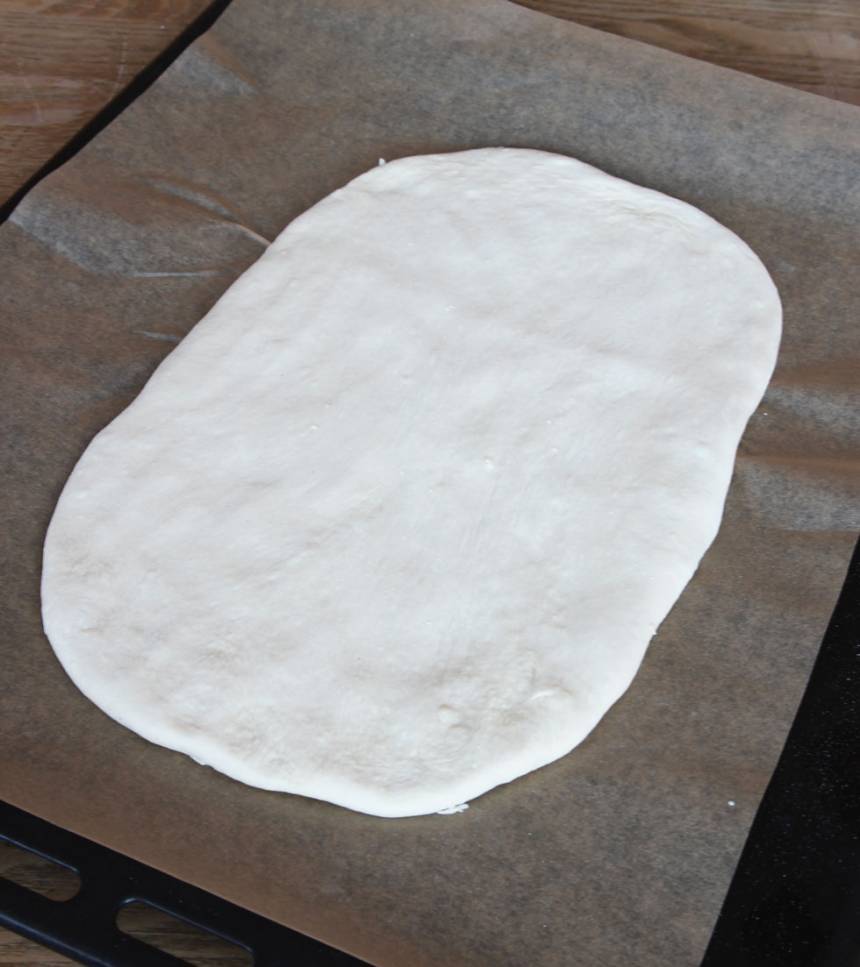 2. Tryck ut degen på en plåt med bakplåtspapper, 1 1/2–2 cm tjock. Låt den jäsa under bakduk i 50–60 min. Sätt ugnen på 230 grader. 