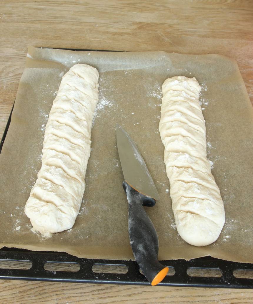 3. Skär sneda snitt i baguetterna med en vass kniv. Låt dem jäsa under bakduk i ca 30 min. Sätt ugnen på 250 grader. 
