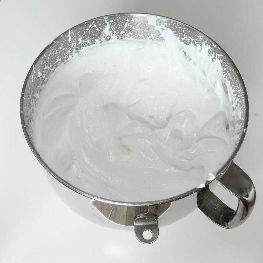 3. Häll den varma gelatinblandningen i sockermassan och vispa kraftigt med en elvisp eller i en bakmaskin tills massan är vit och fluffig. 