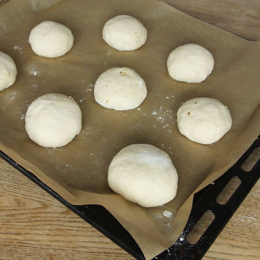 6. Lägg bollarna på en plåt med bakplåtspapper. Låt dem jäsa under bakduk i ca 20 min. Sätt ugnen på 250 grader.