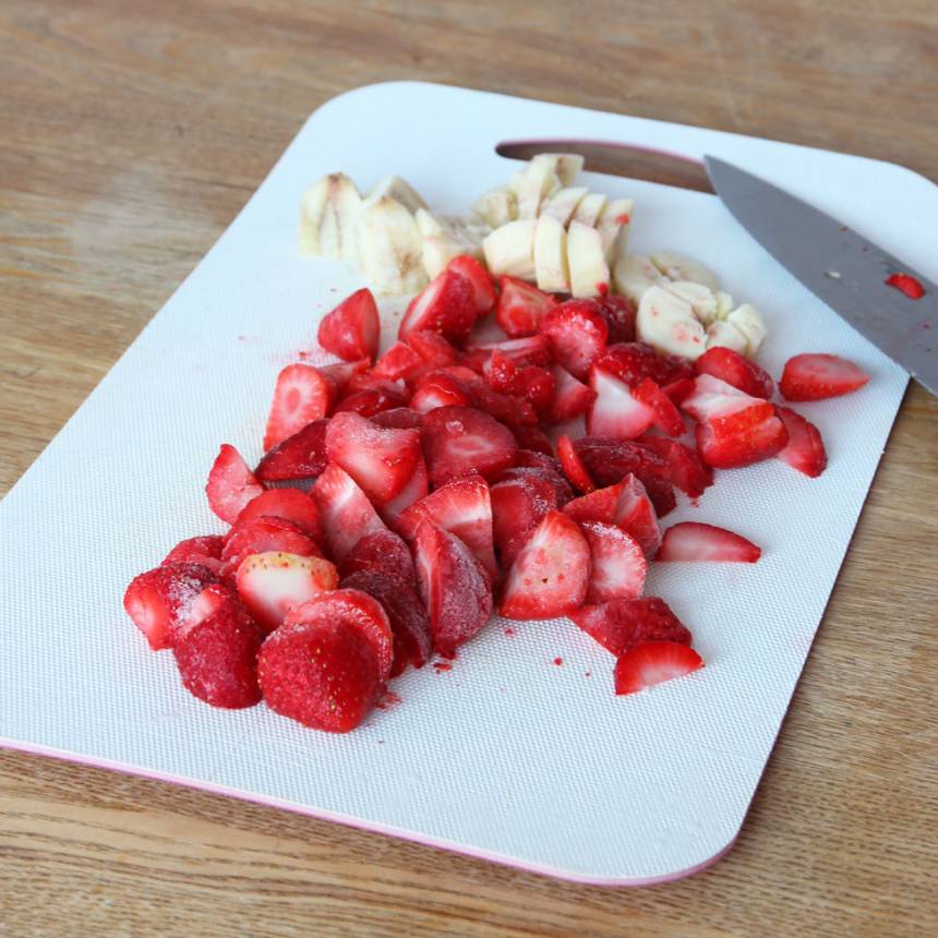 1. Skär de frysta jordgubbarna och bananen i bitar. Låt dem eventuellt ligger framme några minuter så är de enklare att skära, men inte för länge så de tinar. 