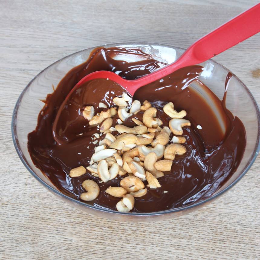 3. Blanda ner nötterna i chokladen.