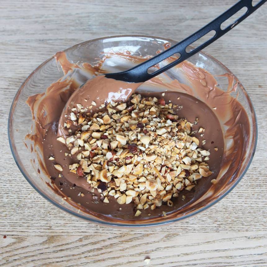 5. Blanda ner ¾ av nötterna i chokladen.