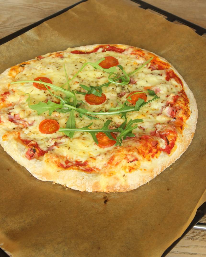 5. Lägg några ruccolablad på pizzan före servering.