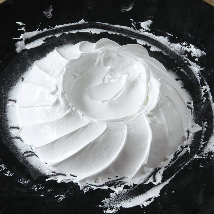 6. Skapa ett mönster på kanten av marängbottnen genom att dra fåror tätt intill varandra runt hela tårtan, med en spatel eller sked, nedifrån botten och snett upp. Forma en grund grop i mitten. 