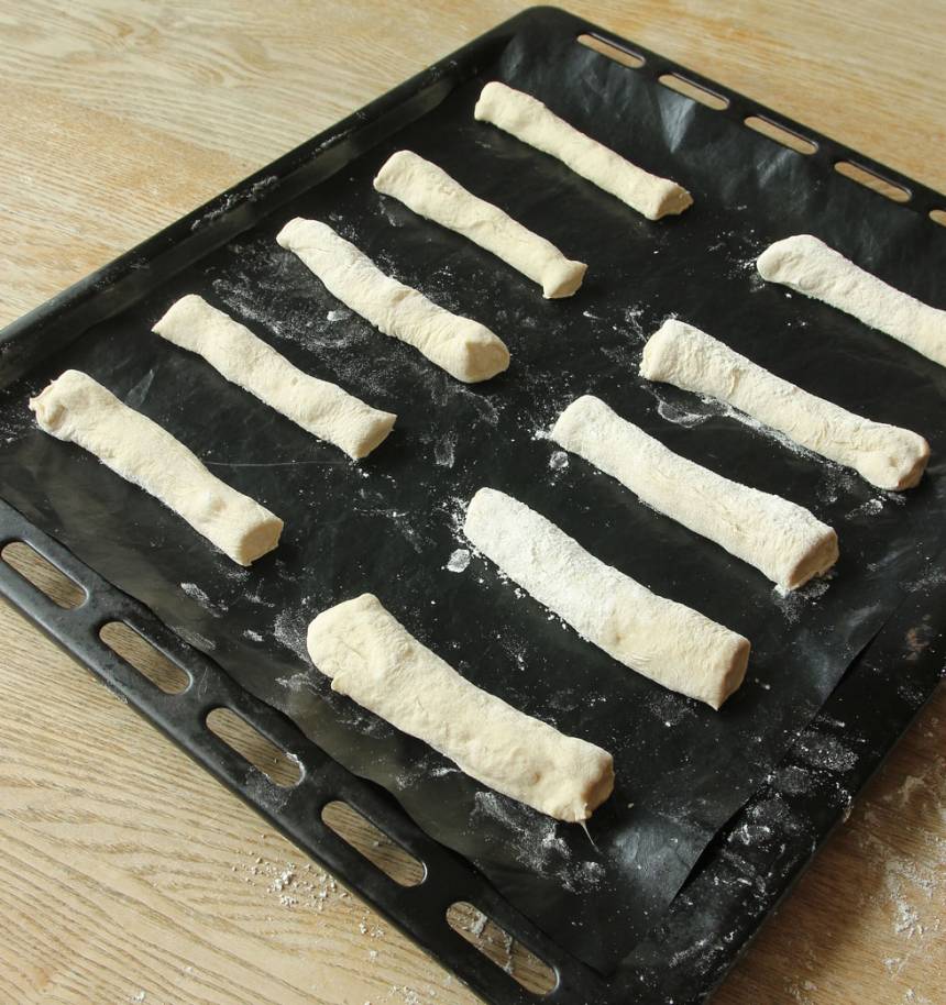 3. Lägg bitarna brett isär på en plåt med bakplåtspapper. Låt dem jäsa under bakduk i ca 30 min. Sätt ugnen på 250 grader. 