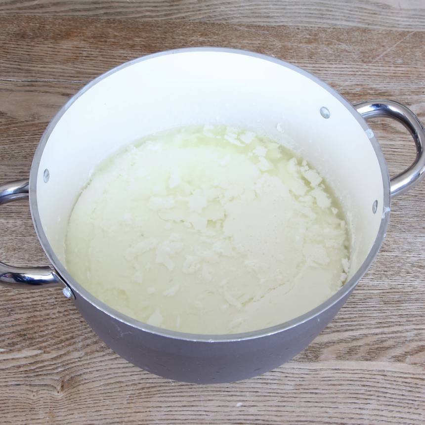 3. Häll tillbaka mjölk- och yoghurtblandningen i kastrullen. Rör om ordentligt. Fyll upp varmvatten i diskhon och ställ kastrullen i det varma vattenbadet med en lock ovanpå. Låt yoghurten stå och tjockna i 8–10 timmar (vattnet svalnar långsamt och ska inte fyllas på). Men om yoghurten inte tjocknat tillräcklig efter den långa tiden så fyll upp med nytt varmt vatten i diskhon och låt den stå en stund tills den tjocknar. När yoghurten är klar har den tjocknat och vätskan har separerats från den. 