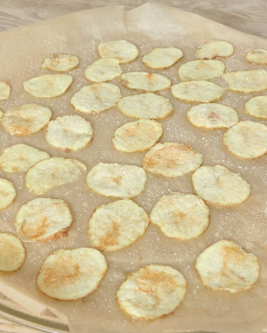 4. Kör potatisarna i mikron i 5–9 min tills de får en gulbrun färg. Tiden varierar beroende på hur många potatisskivor du har och vilken styrka din mikro har. Om du har en liten mikro och bara får plats med en vanlig måltidstallrik får du köra en potatis i taget. Då tar det 3–4 minuter i mikron. Låt potatisarna kallna på pappret. 