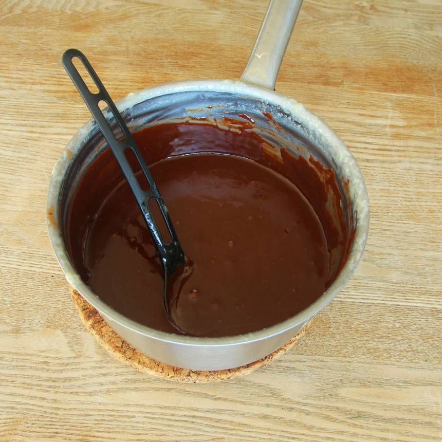 4. Koka upp vispgrädde, sirap, strösocker och kakao. Låt det puttra till 120 grader (använd en digitaltermometer). Det tar ca 15 min. Tillsätt sedan ättiksprit och rör om ordentligt. Stäng av spisvärmen. Tillsätt sist smör och choklad och låt det smälta. Rör om till en slät smet. 