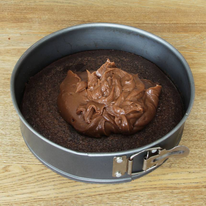 6. Bred ut ganachen över kladdkakan. Strö över hackad choklad. Ställ tårtan i kylen i ett par timmar och låt den stelna.