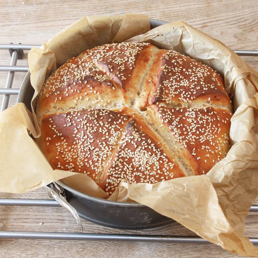 4. Grädda brödet mitt i ugnen i 13–15 min. Sänk värmen till 230 grader när du sätter in brödet. Lyft upp brödet i papperet och låt det svalna under en bakduk.