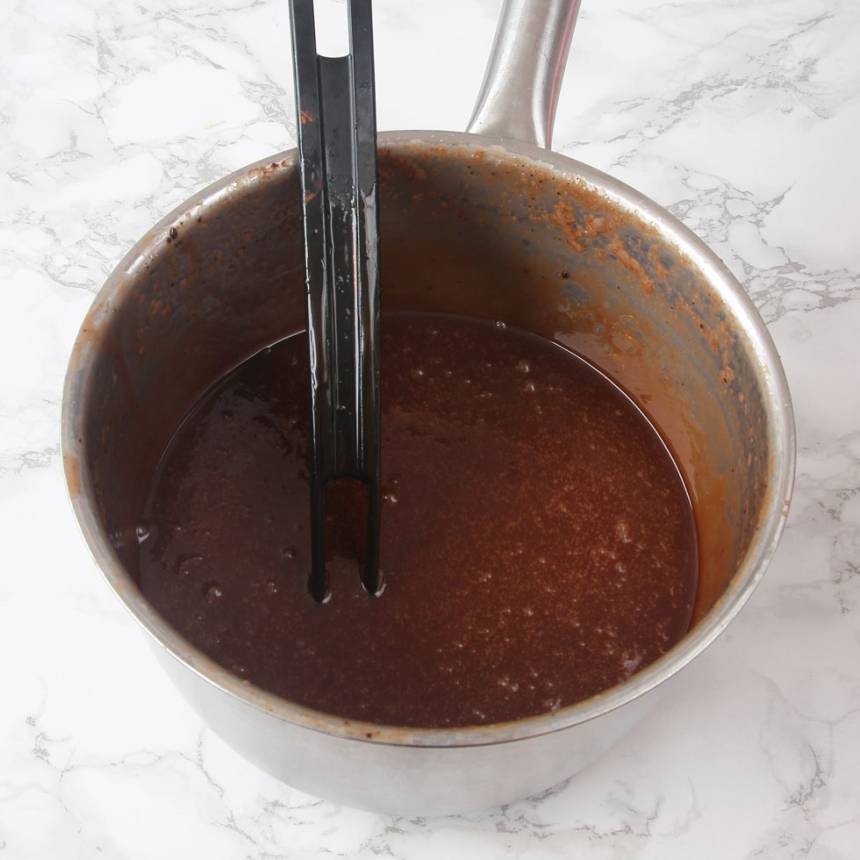 3. Blanda vispgrädde, sirap, strösocker och kakao i en 3–4 liters kastrull. Låt det koka till ca 124 grader. Stäng av värmen och tillsätt smöret. Rör om ordentligt. 