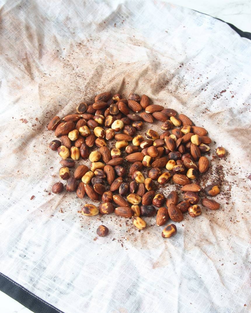 5. Lägg nötter och mandlar i en ren kökshandduk. Gnugga dem med handduken så att överflödigt skal lossnar. Släng bort skalet. 