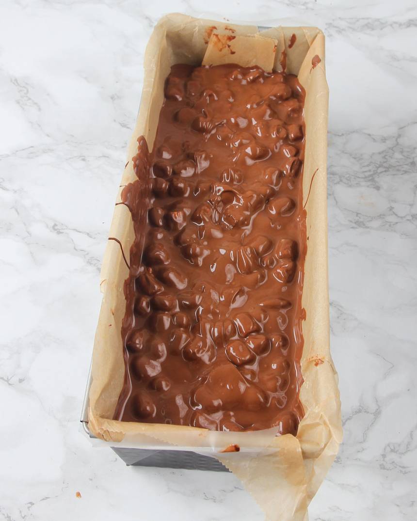 8. Ta fram formen ur kylen. Häll chokladsmeten i formen. Ställ den i frysen en stund tills ytan stelnar. 