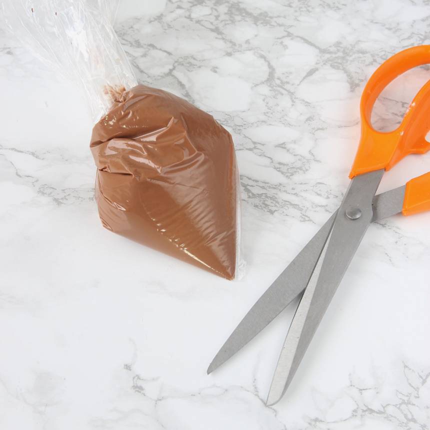 5. Garnering: Smält chokladen och lägg den i en plastpåse. Knyt påsen och klipp ett hål i ena hörnet. 