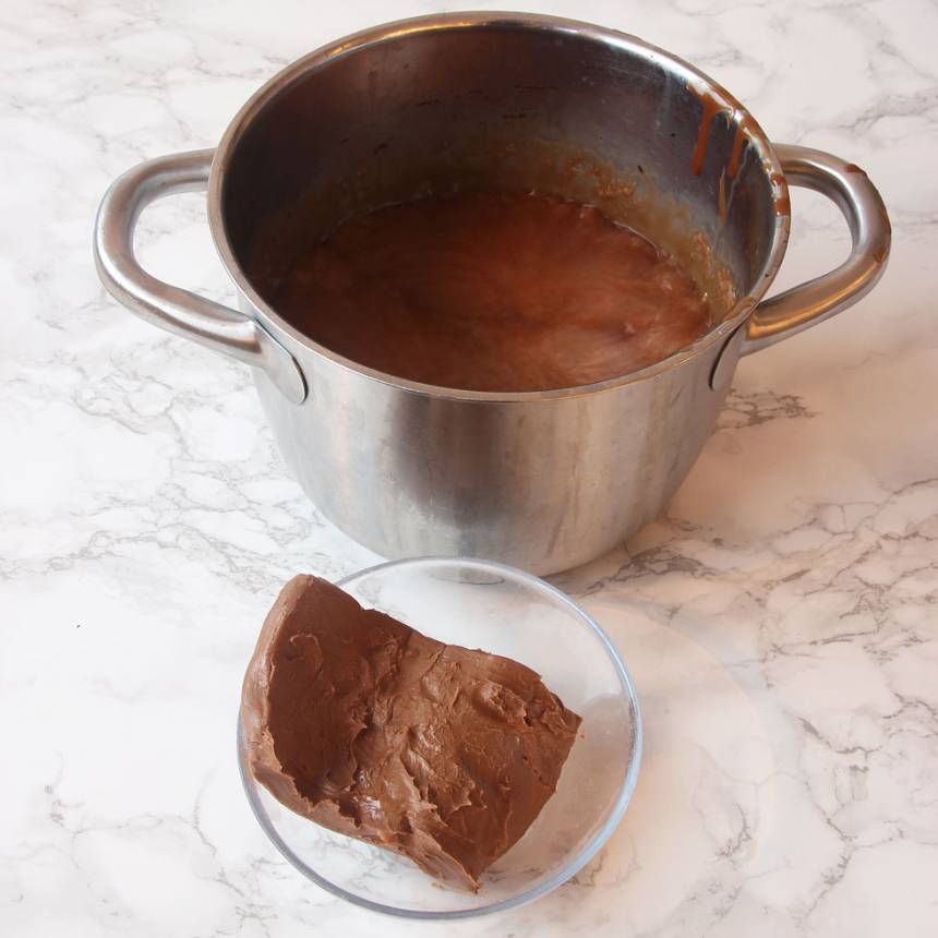 2. Blanda vispgrädde, sirap, strösocker och kakao i en 3–4 liters kastrull. Låt det koka till ca 124 grader. Stäng av värmen och tillsätt nougat och smör. Blanda ordentligt och rör om till en slät smet. 