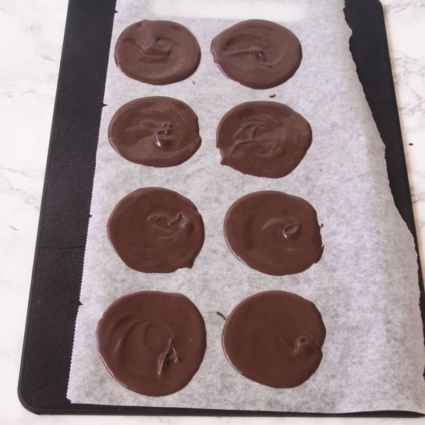 2. Bred ut chokladen tunt till runda plattor, 10–12 cm i diameter på en bricka med bakplåtspapper. 