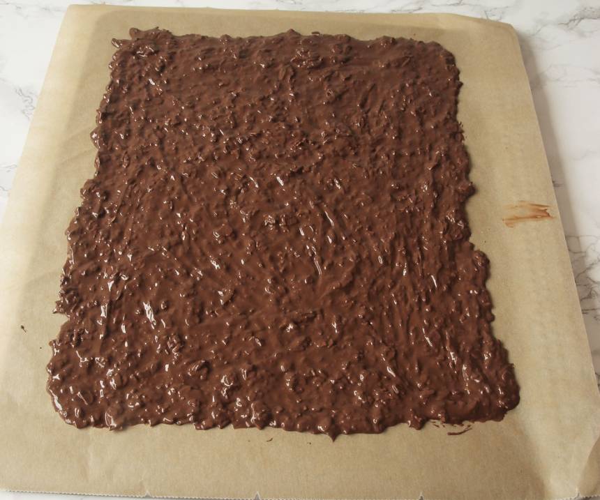 4. Bred ut chokladsmeten tunt på ett bakplåtspapper. Låt den stelna i kylen. Bryt chokladen i bitar när den fortfarande är kall. Förvara chokladen i kylen eftersom den kan bli lite mjuk i rumstemperatur.