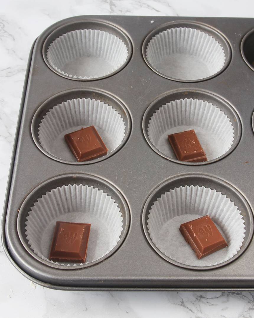2. Ställ ut 12–15 muffinsformar på en plåt (eller i en muffinsform). Lägg 1 chokladbit i varje form (valfritt). 