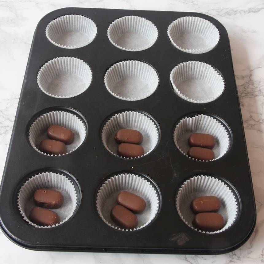 2. Ställ ut 12–15 muffinsformar på en plåt (eller i en muffinsform). Lägg 1–2 Dumlekolor i varje form (valfritt). 