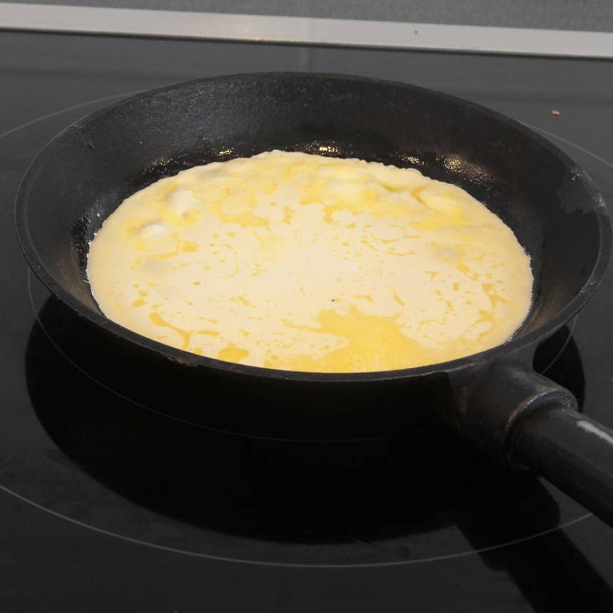4. Häll ett tunt lager smet i stekpannan. Sänk värmen ett par steg. Vänd pannkakan när smeten börjar stelna. 