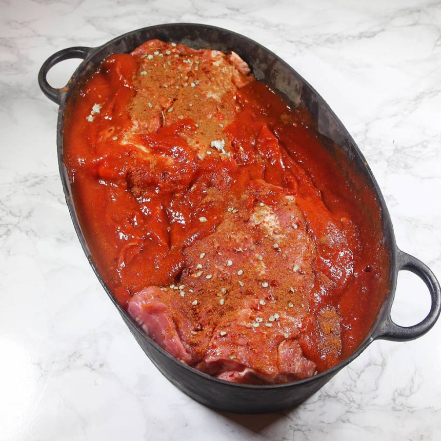 2. Blanda de passerade tomaterna med chilisåsen och häll det runt köttet i grytan. 