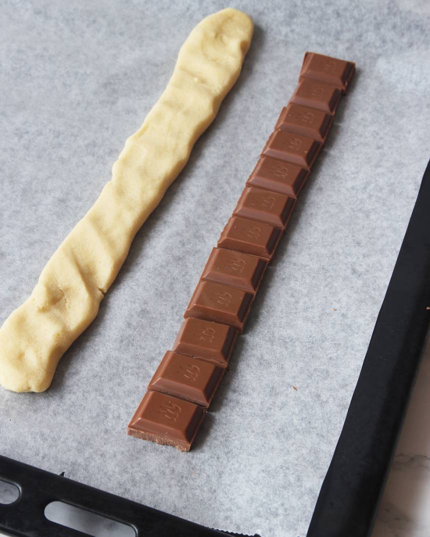3. Lägg ut tre rader med mjölkchokladbitar, ca 25 cm långa, på en plåt med bakplåtspapper. 